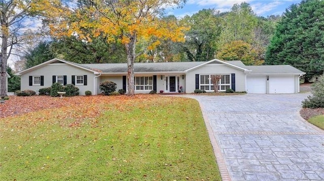 ranch-style home with a garage, decorative driveway, and a front yard