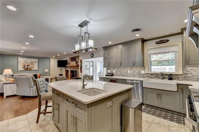 kitchen with open floor plan, a sink, and gray cabinetry