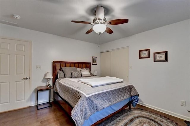 bedroom with a ceiling fan, a closet, baseboards, and wood finished floors