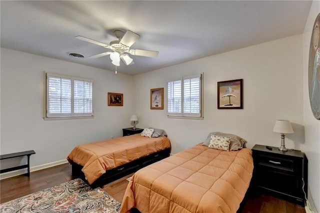 bedroom featuring visible vents, dark wood-type flooring, a ceiling fan, and baseboards