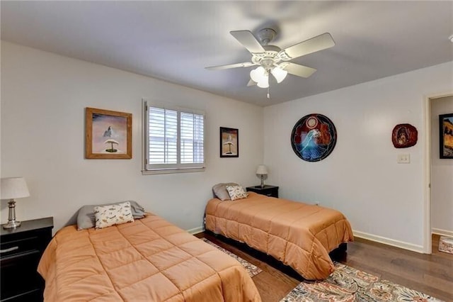 bedroom featuring wood finished floors, a ceiling fan, and baseboards