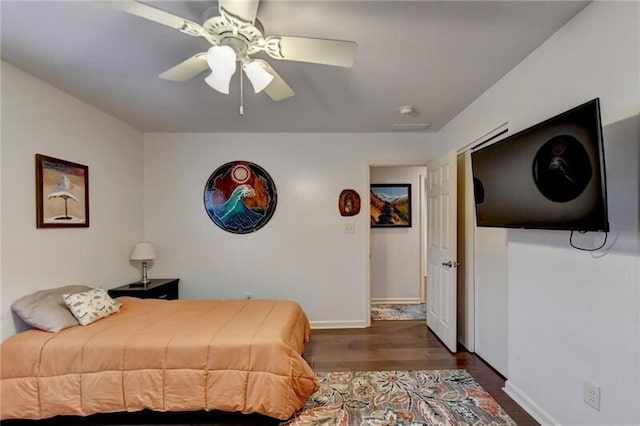 bedroom featuring a ceiling fan, baseboards, and wood finished floors