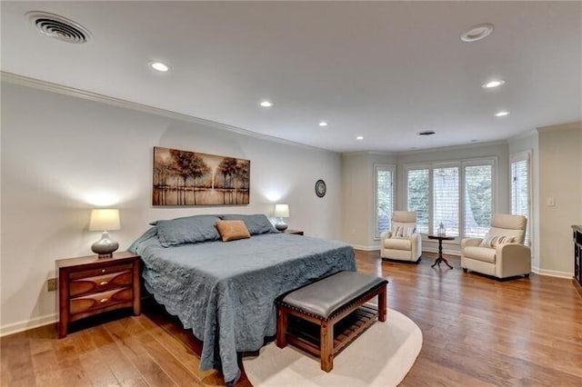 bedroom with recessed lighting, wood finished floors, visible vents, baseboards, and ornamental molding