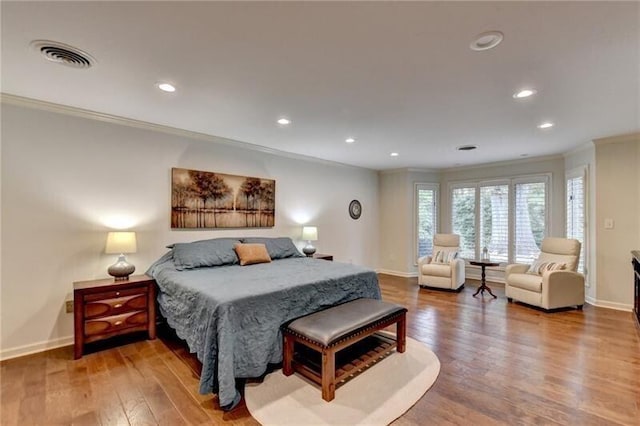 bedroom featuring baseboards, visible vents, ornamental molding, wood finished floors, and recessed lighting