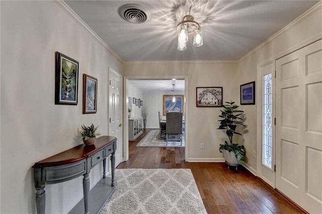 entryway featuring baseboards, visible vents, hardwood / wood-style floors, and ornamental molding