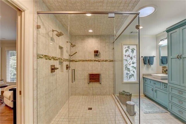 bathroom with a stall shower, tile patterned floors, vanity, and crown molding