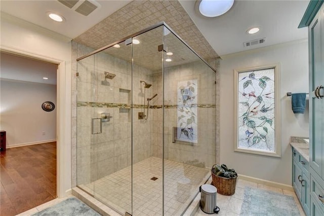 bathroom with visible vents, a shower stall, and baseboards