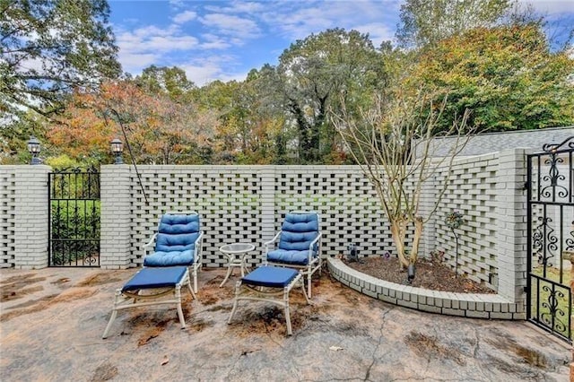 view of patio with a gate and fence