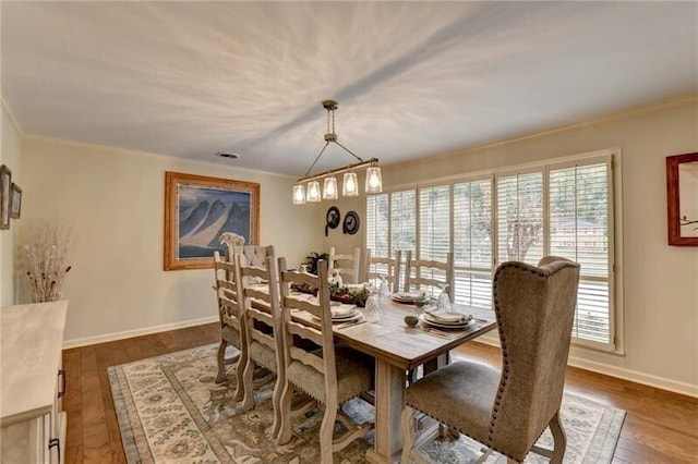 dining room with hardwood / wood-style flooring, baseboards, and ornamental molding