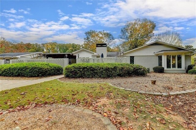 view of front of home featuring brick siding and fence