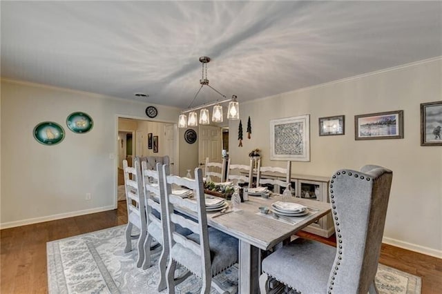 dining area with crown molding, baseboards, and wood finished floors