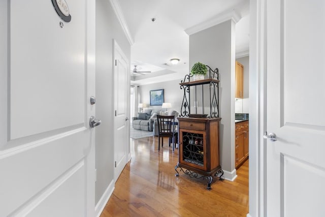 corridor with crown molding and light wood-type flooring