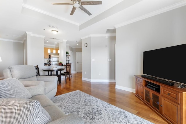 living room featuring ornamental molding, light hardwood / wood-style floors, and ceiling fan