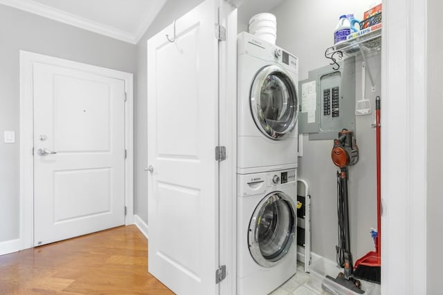 clothes washing area featuring stacked washer and dryer, crown molding, and light hardwood / wood-style flooring