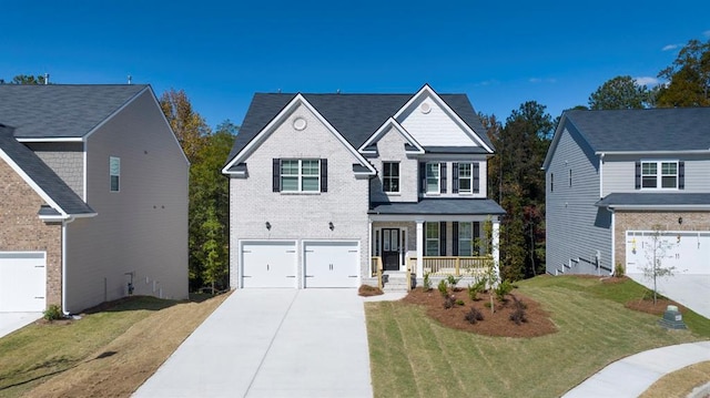 view of front of home with a porch, a garage, and a front yard