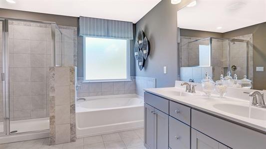 bathroom with tile patterned flooring, vanity, and separate shower and tub