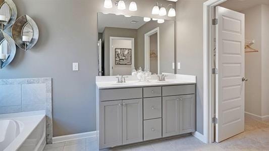 bathroom featuring tile patterned flooring, vanity, and a bath