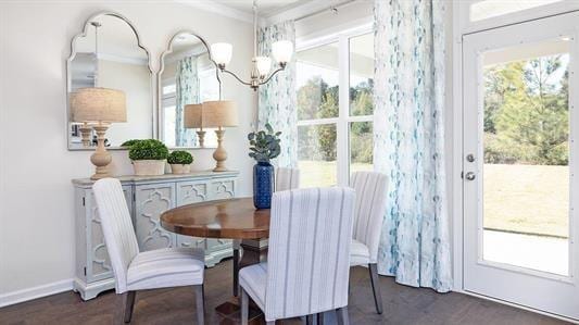 dining space featuring a chandelier, ornamental molding, plenty of natural light, and dark wood-type flooring