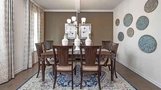 dining space featuring hardwood / wood-style flooring, ornamental molding, and an inviting chandelier