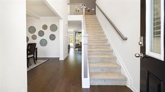 stairway with hardwood / wood-style floors and beamed ceiling