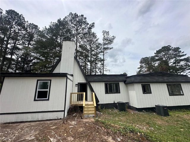 6774 Collier Rd, Riverdale, GA 30296 - view of front facade with central air condition unit and a chimney