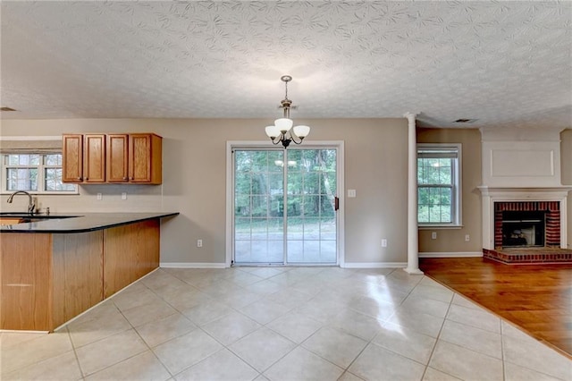 5229 Pine Branch Ct, Sugar Hill, GA 30518 - kitchen with open floor plan, light tile patterned flooring, healthy amount of natural light, brown cabinets, and a textured ceiling