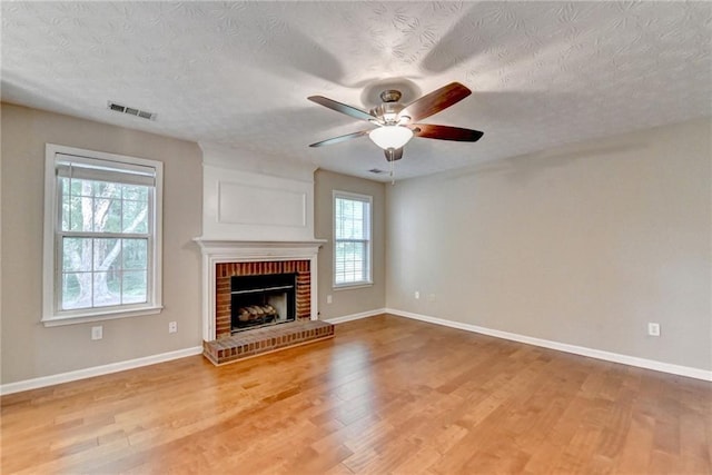 5229 Pine Branch Ct, Sugar Hill, GA 30518 - unfurnished living room featuring wood finished floors, ceiling fan, baseboards, a brick fireplace, and a textured ceiling