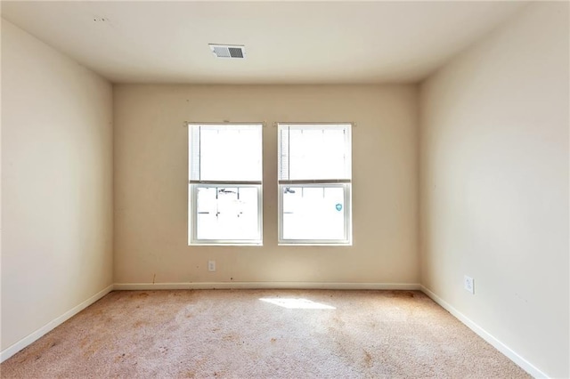 carpeted empty room with baseboards and visible vents