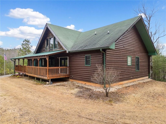 exterior space with roof with shingles and driveway