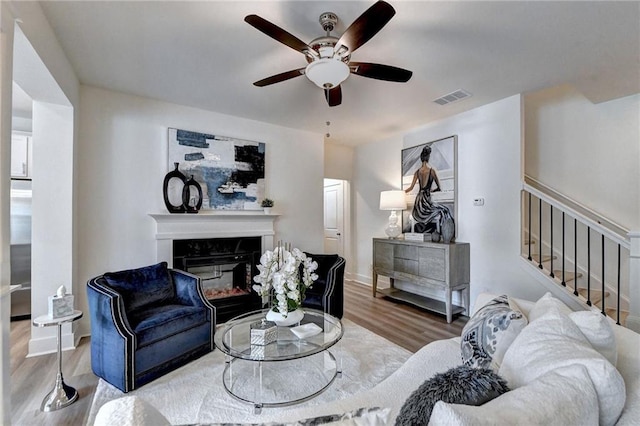 living room with wood-type flooring and ceiling fan