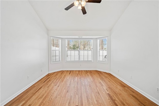 unfurnished room with baseboards, lofted ceiling, light wood-style floors, and a ceiling fan