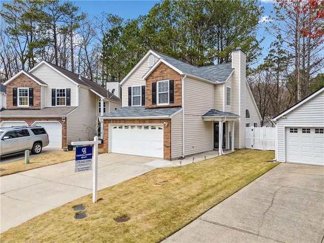 traditional-style home with brick siding, concrete driveway, a front yard, a chimney, and a garage