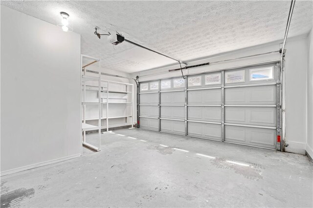 garage with a garage door opener and baseboards