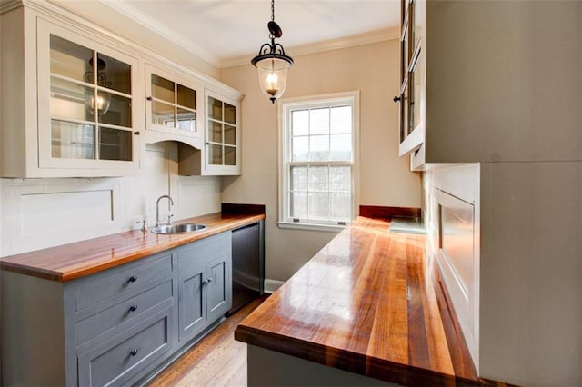 kitchen featuring pendant lighting, wood counters, sink, and gray cabinetry