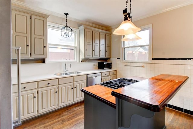 kitchen with pendant lighting, sink, wooden counters, ornamental molding, and stainless steel appliances