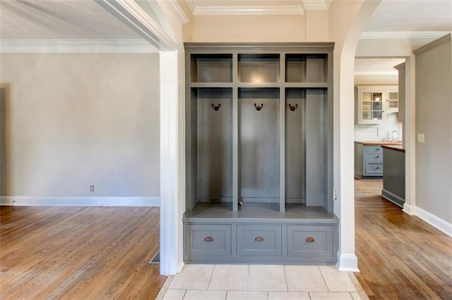 mudroom featuring crown molding, sink, and light hardwood / wood-style floors