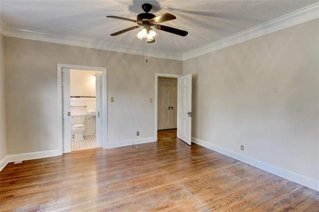 unfurnished bedroom with connected bathroom, wood-type flooring, ornamental molding, and ceiling fan