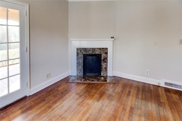 unfurnished living room with hardwood / wood-style flooring and a high end fireplace