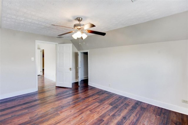 spare room featuring ceiling fan, lofted ceiling, dark hardwood / wood-style flooring, and a textured ceiling