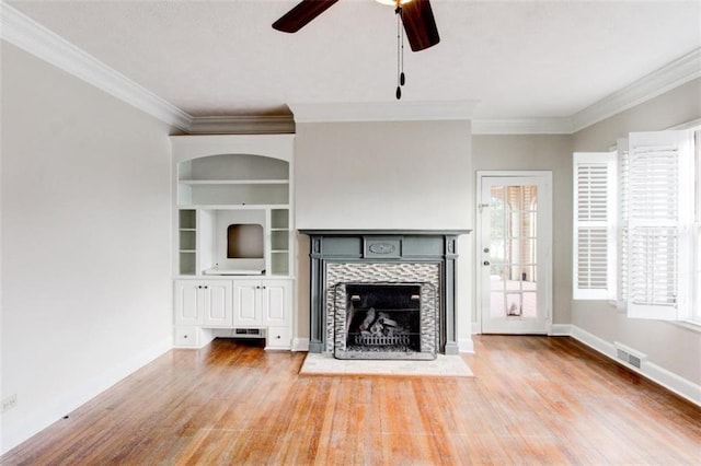 unfurnished living room with a fireplace, crown molding, and wood-type flooring