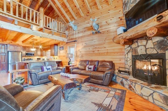 living room featuring beam ceiling, wooden ceiling, and a fireplace