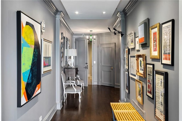 hall featuring crown molding, dark hardwood / wood-style flooring, and a chandelier