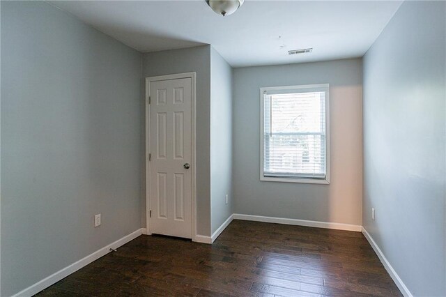 unfurnished room featuring dark wood-type flooring