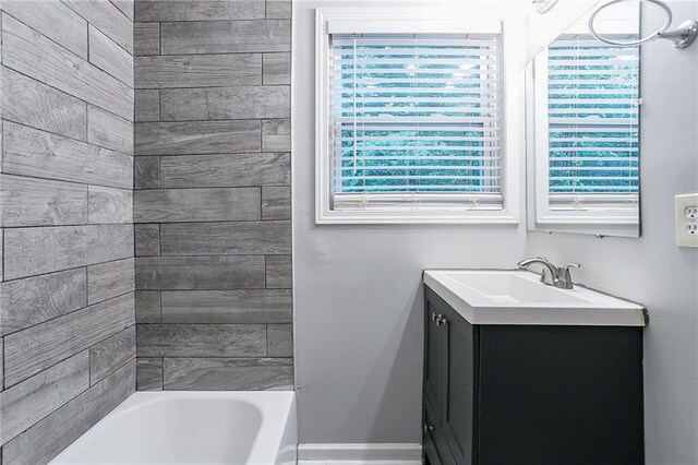 bathroom with vanity, a bathtub, and a wealth of natural light