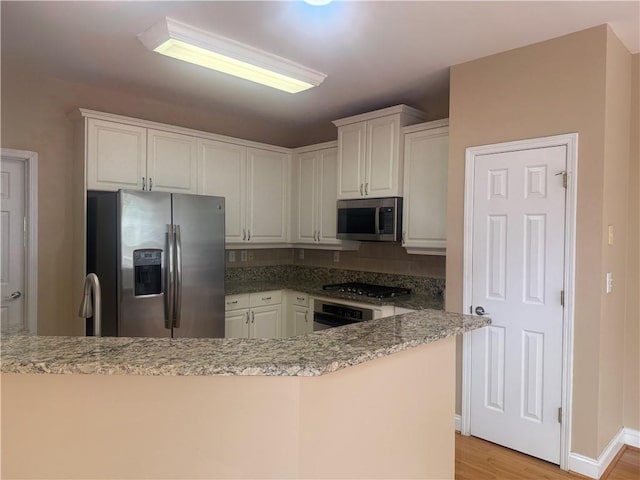 1919 Barrett Knoll Cir NW, Kennesaw, GA 30152 - kitchen with appliances with stainless steel finishes, white cabinets, light wood-style floors, and light stone counters