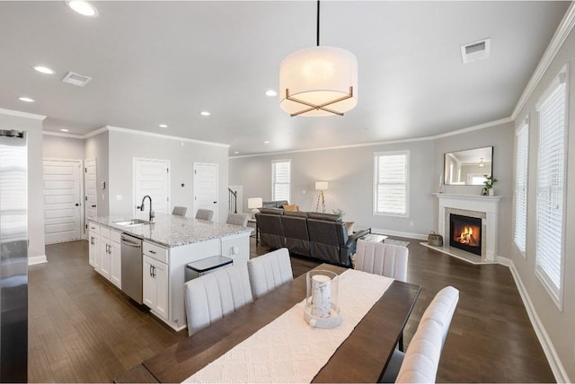 dining room featuring dark wood-style floors, baseboards, crown molding, and a high end fireplace