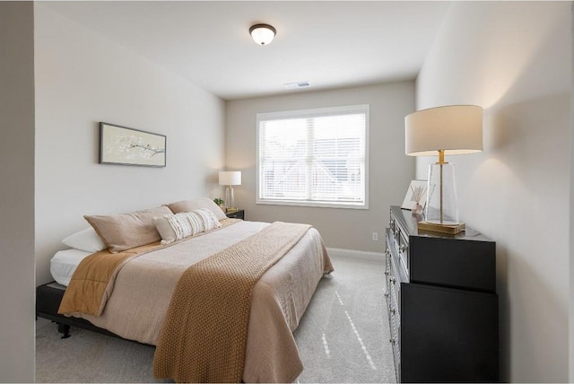 bedroom with light carpet, visible vents, and baseboards