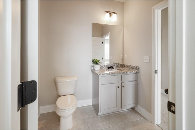 bathroom with baseboards, vanity, toilet, and tile patterned floors