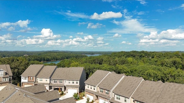 drone / aerial view featuring a water view, a residential view, and a view of trees