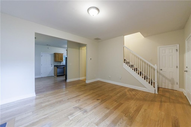 3135 Washington Rd, Atlanta, GA 30344 - unfurnished living room featuring stairs, light wood-style floors, and baseboards